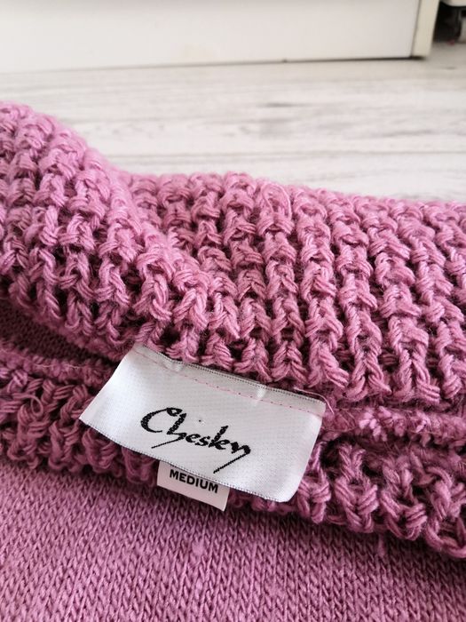 Różowy sweter sweterek odwijanym kołnierz.