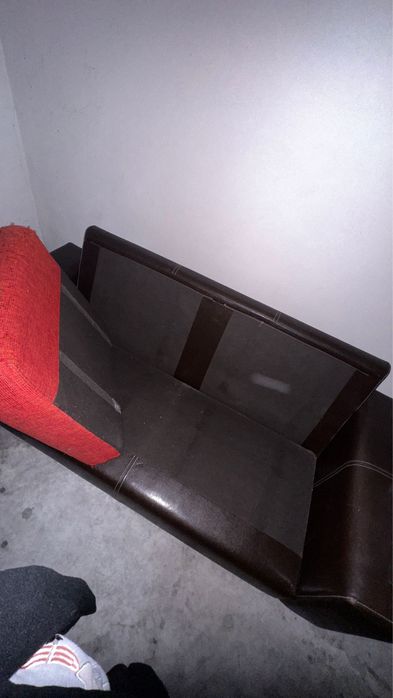 Sofá castanho em pele, com encostos e assentos em almofadas,.