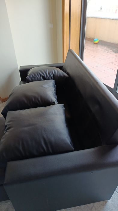 sofá em pele sintética (napa), cor preta, com chaise longue.