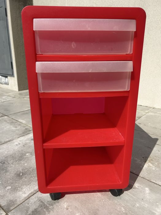 Pequeno móvel de plástico vermelho, com rodas, prateleira e 2 gavetas