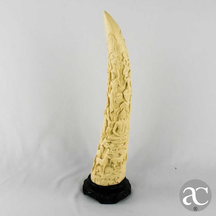 Escultura marfinite forma de dente de elefante com figuras orientais