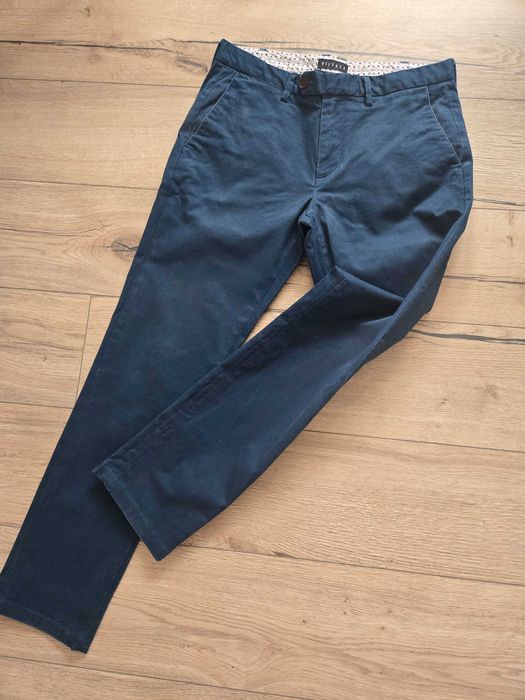 W super kolorze granat wpadający w butelkową zieleń męskie chinosy marki Vistula