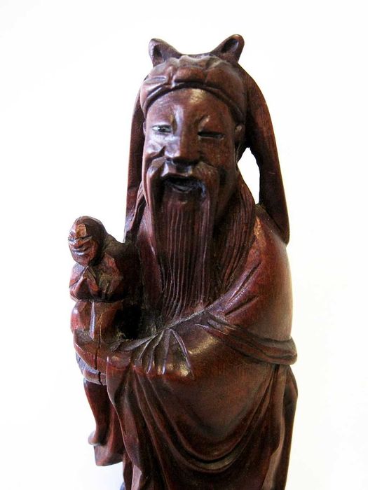 antiga escultura de um sábio asiático esculpido em madeira