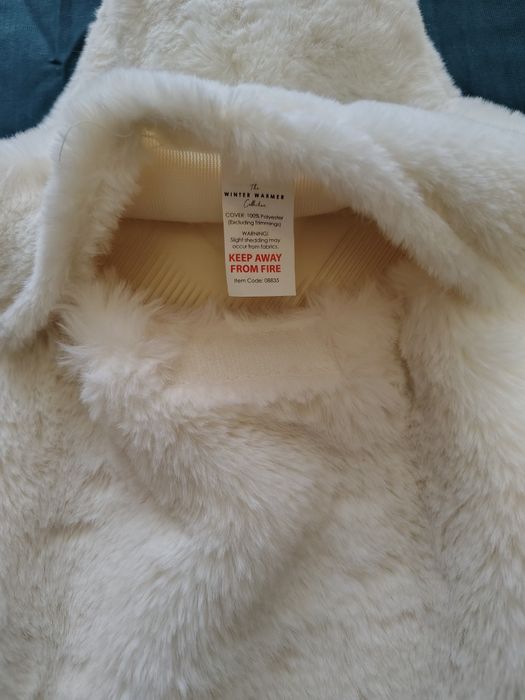 Грілка з пухнастим чохлом та помпонами.