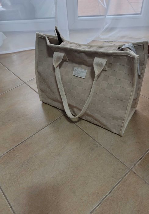 Sprzedam beżową torebkę z krótkimi uchwytami.