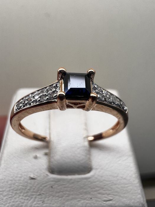 женское золотое кольцо усеянное бриллиантами и сапфиром