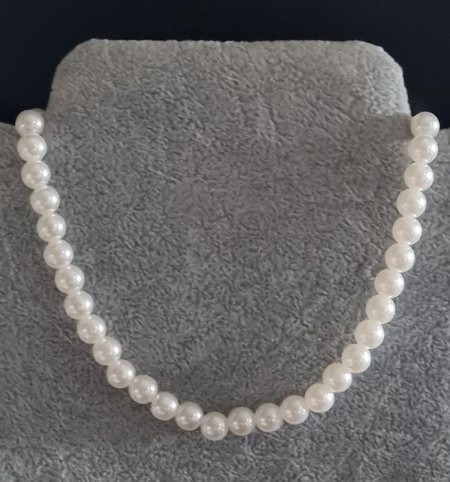 Colar/choker de pérolas com acabamento dourado em açol. Tem extensor