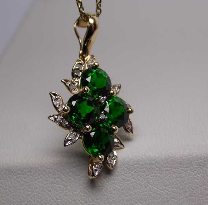 Złota zawieszka zielone diopsydy chromowe i diamenty.