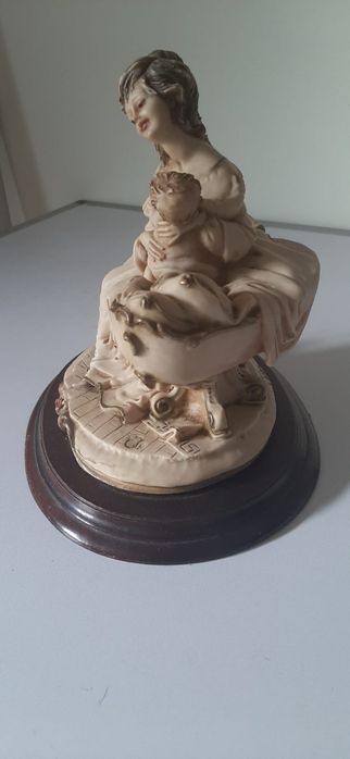 Escultura de mãe e filho em base de madeira