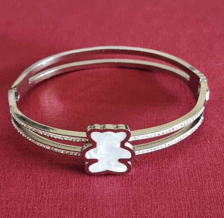 Pulseira/escrava prateada, em aço, com zirconias e um urso em madrepér