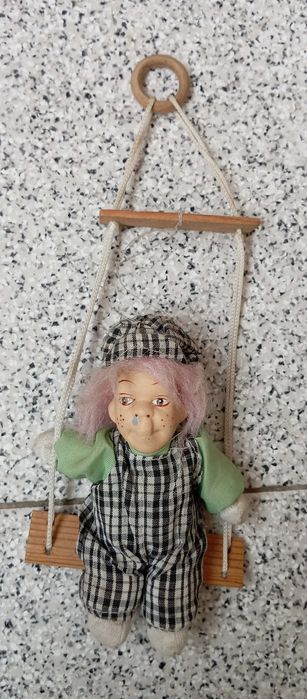 Boneco antigo no baloiço porcelana