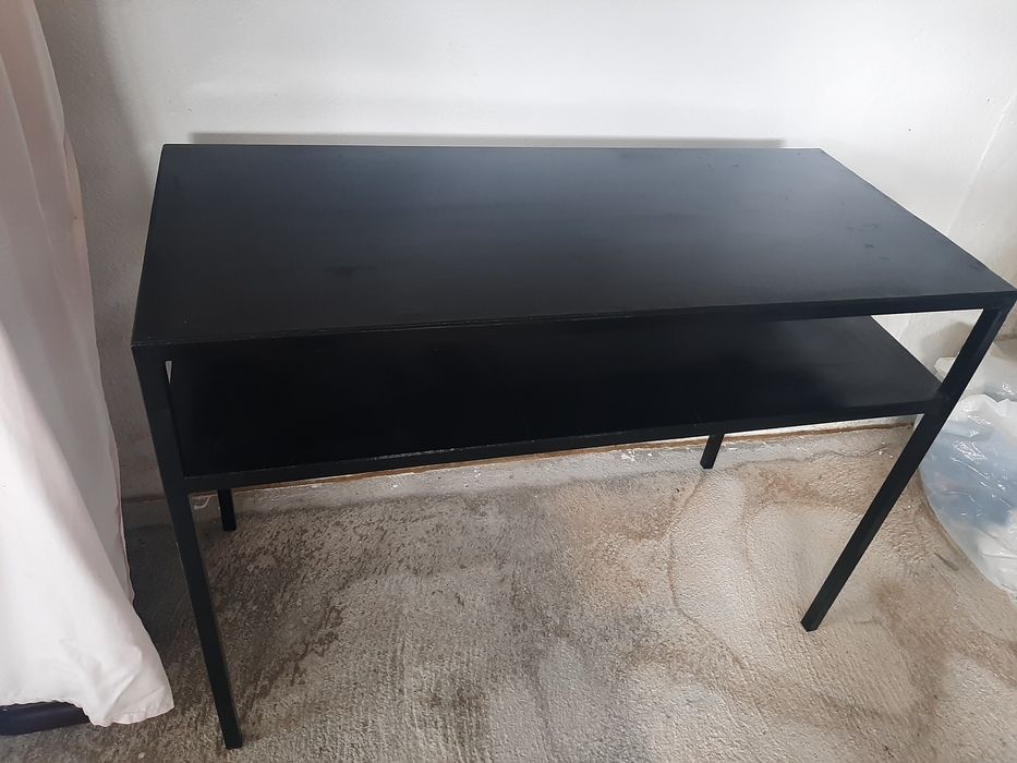 Consola em metal com uma prateleira.