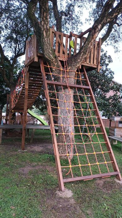 Parque infantil na árvore con tirolesa e ponte suspensa.