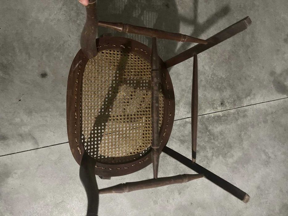 Cadeira de madeira rústica com braços e assento de palha