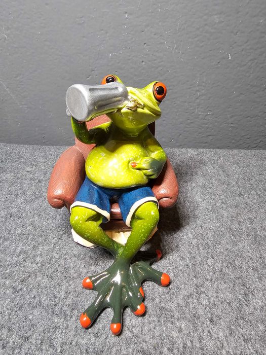 Żaba w fotelu pijąca piwo