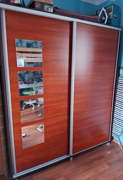 Duża szafa z drzwiami przesuwnymi i lustrem.