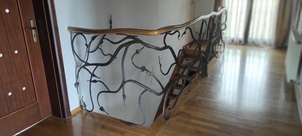 Piękne dębowe schody z kuta barierka i giętą poręczą