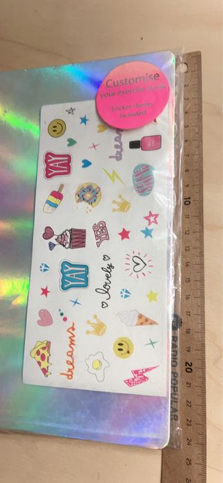 Três cadernos capa prateada com autocolantes