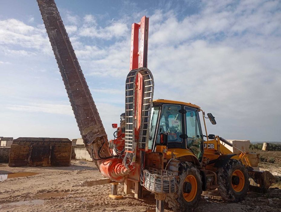 Máquina JCB com serrote de corte de pedra