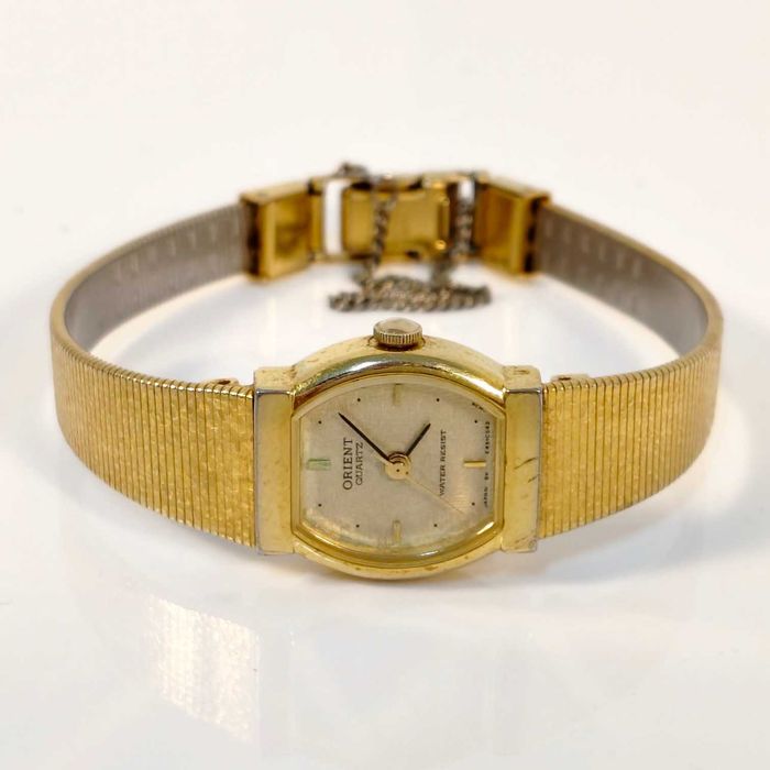 Relógio de pulso de senhora, Orient, caixa em metal dourado, bracelete em malha de metálica integrada em dourado. Movimento a quartz a funcionar