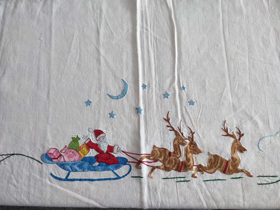 Toalha de natal branca com bordados natalícios.