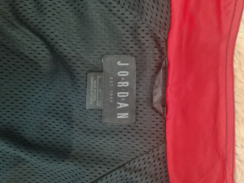 Jordan Sportswear AJ 5 w kolorze czarnym z czerwonymi detalami.