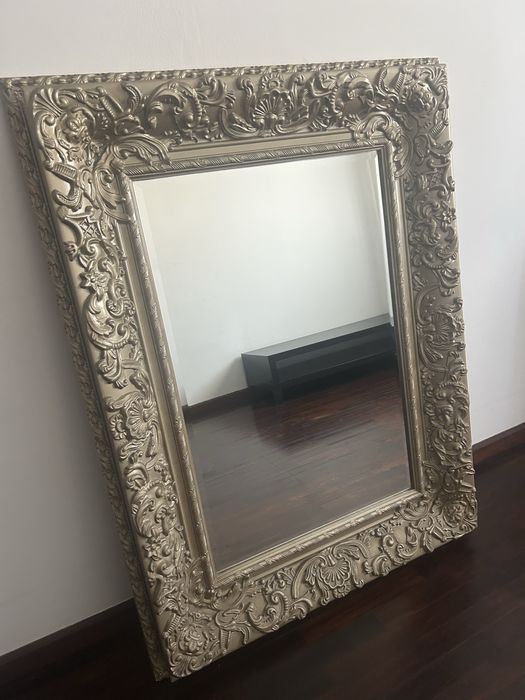 Espelho com moldura dourada.