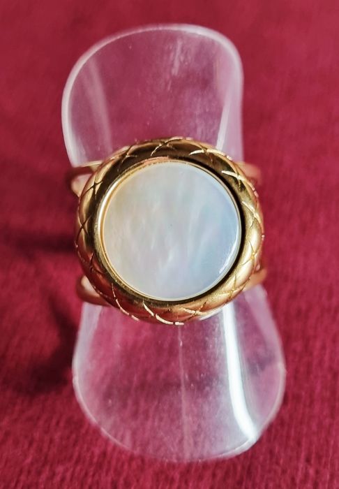 Anel dourado, em aço, com madrepérola redonda. Ajustável