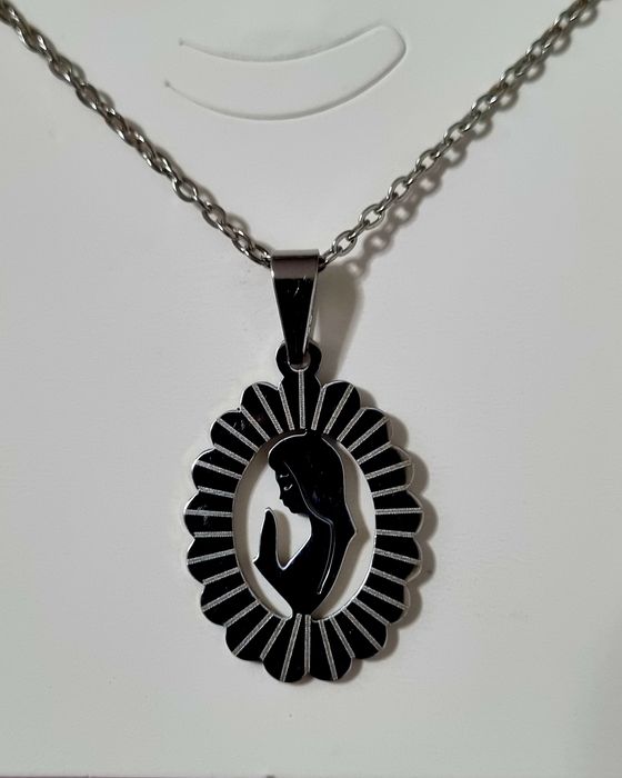 Colar prateado, em aço, com pingente da Nossa Senhora. Tem extensor