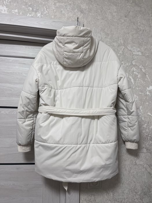 Жіноча біла курточка з поясом.