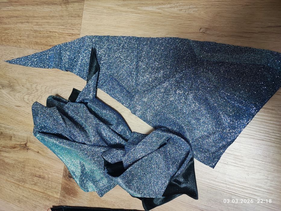 Недошита сукня з блискучої стальної тканини.