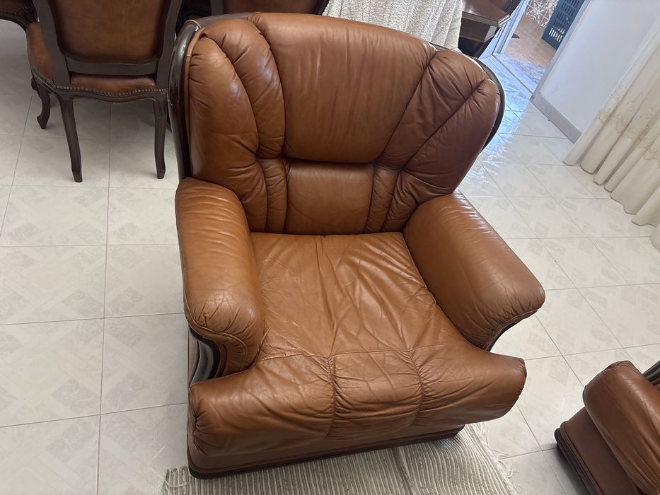Sofa cama em pele  duas poltronas  mesa de sala e um pequeno armario