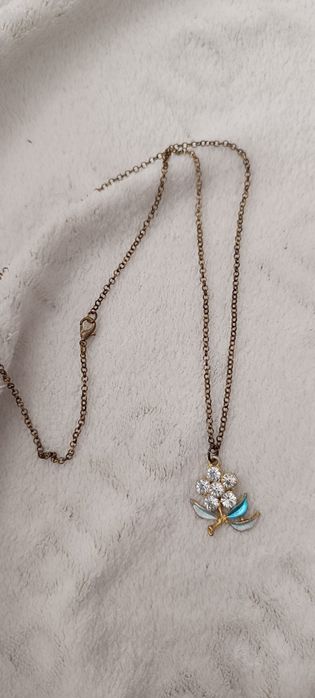 Fio dourado com pendente flor azul e brilhantes