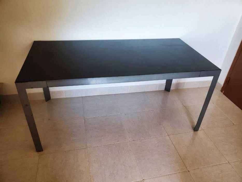Mesa de jantar preta com estrutura em aço