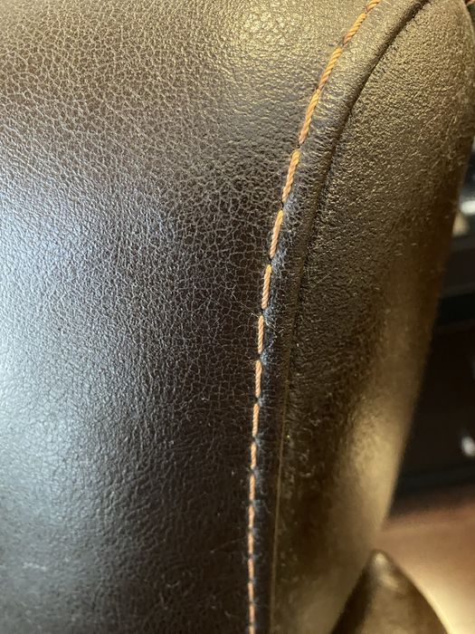 Sofá em pele, na cor castanho e pesponto em bege. Excelente estado