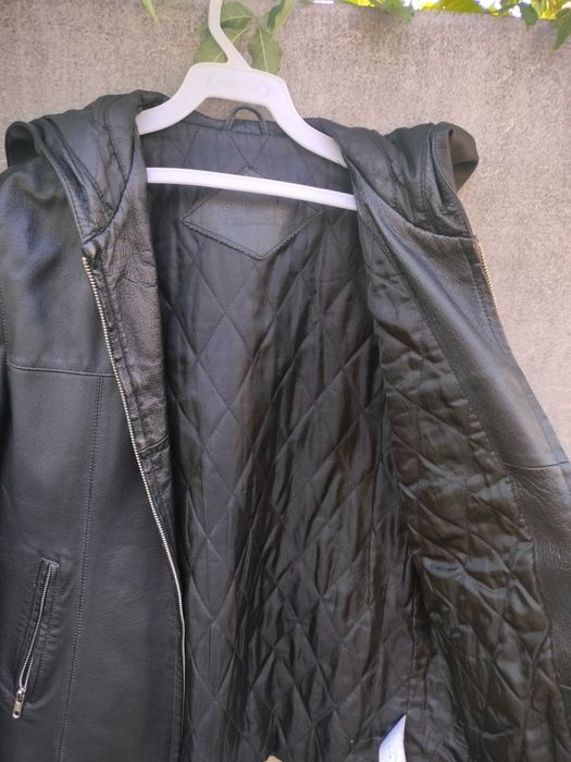 Куртка чорного кольору з натуральної шкіри з капюшоном, утеплена.