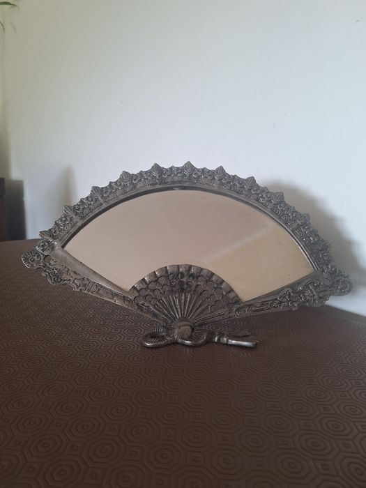 Esespelho em leque 

Espelho com aro metálico em leque, dos anos 80.