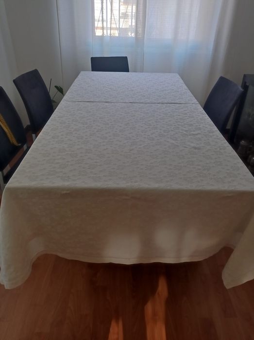 Toalha de mesa branca com motivos florais em destaque