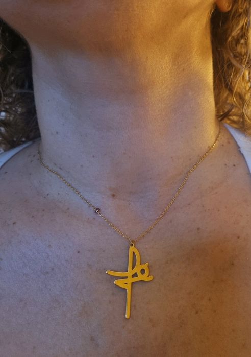 Colar dourado, em aço, a dizer " fé". Tem extensor