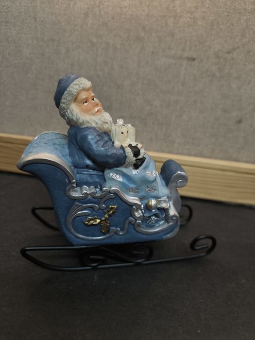 Pai Natal em trenó azul
Figura decorativa de Pai Natal sentado num tre