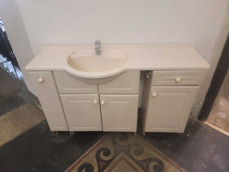 Szafka łazienkowa z umywalka i baterią.