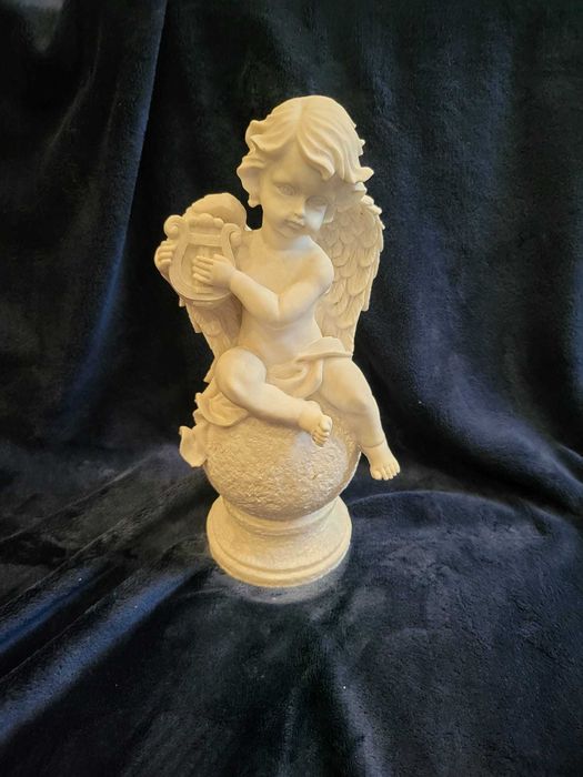 Querubim (anjo-bebé) sentado numa bola em Marfinite