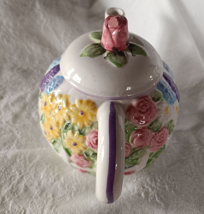 Bule em cerâmica pintado à mão com um padrão floral em relevo