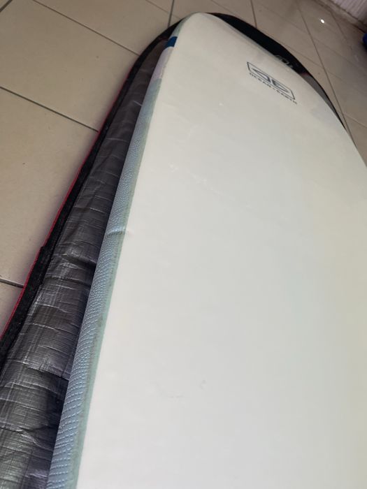 Prancha de surf Ocean & Earth Happy Hour Epoxy Softop 7.0 (52L) em bom estado geral, vendida com capa de proteção.