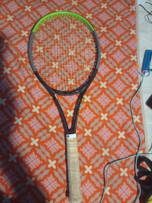 raquete de ténis é uma Wilson Blade V7, reconhecível pelo seu design