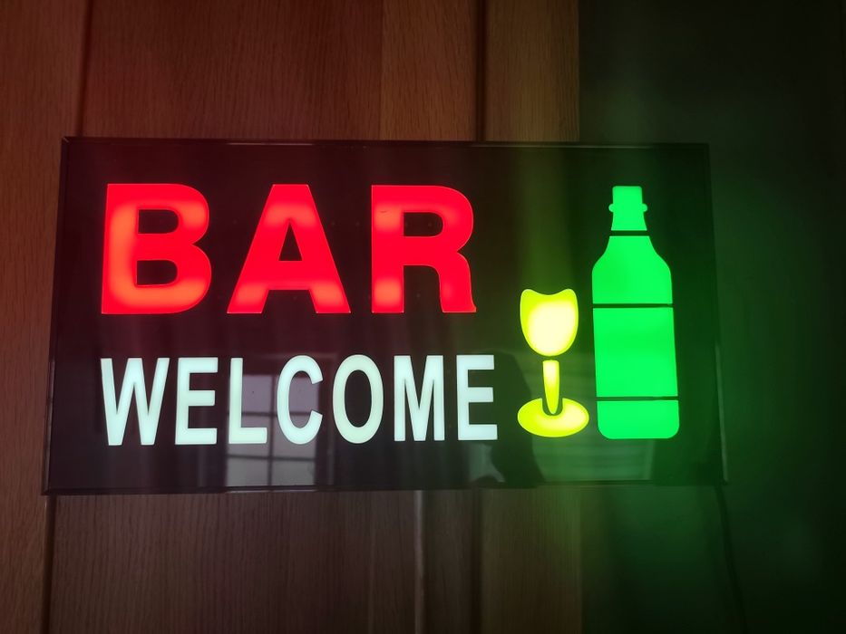Letreiro luminoso LED "Bar Welcome" com garrafa e copo em cores vermelho e verde.