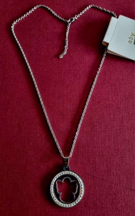 Colar prateado, em aço, pingente de anjinho rodeado de zirconias