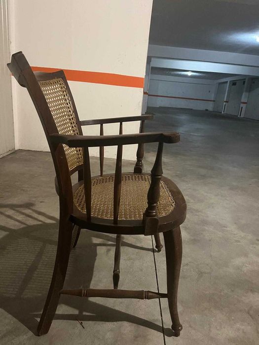 Cadeira de madeira rústica com braços e assento de palha