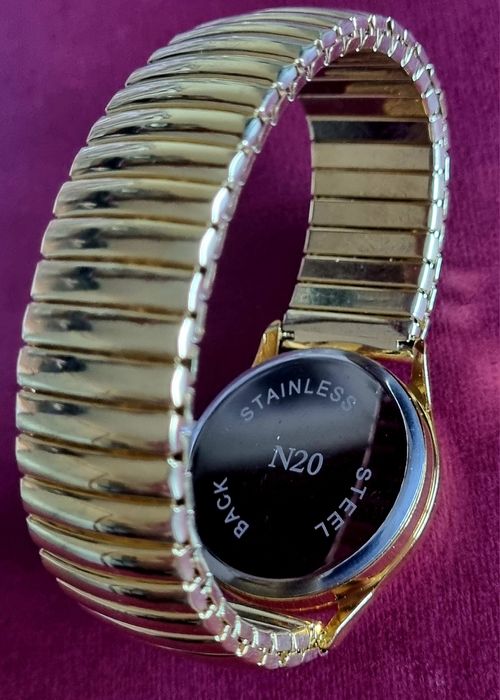 Relógio dourado, elástico, com mostrador em aço.