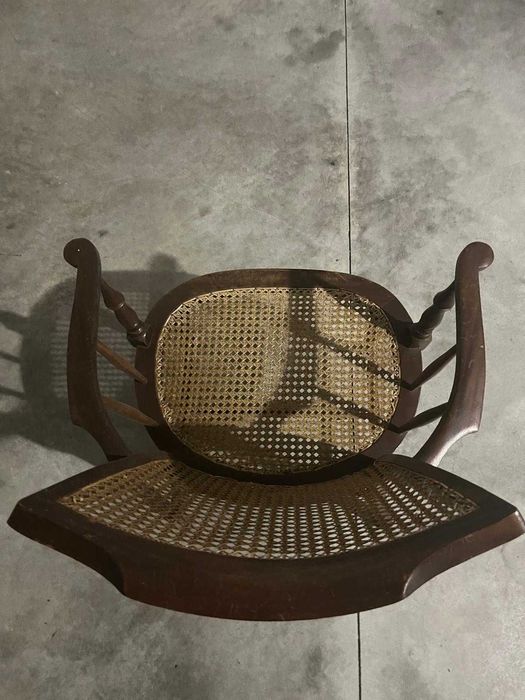 Cadeira de madeira rústica com braços e assento de palha